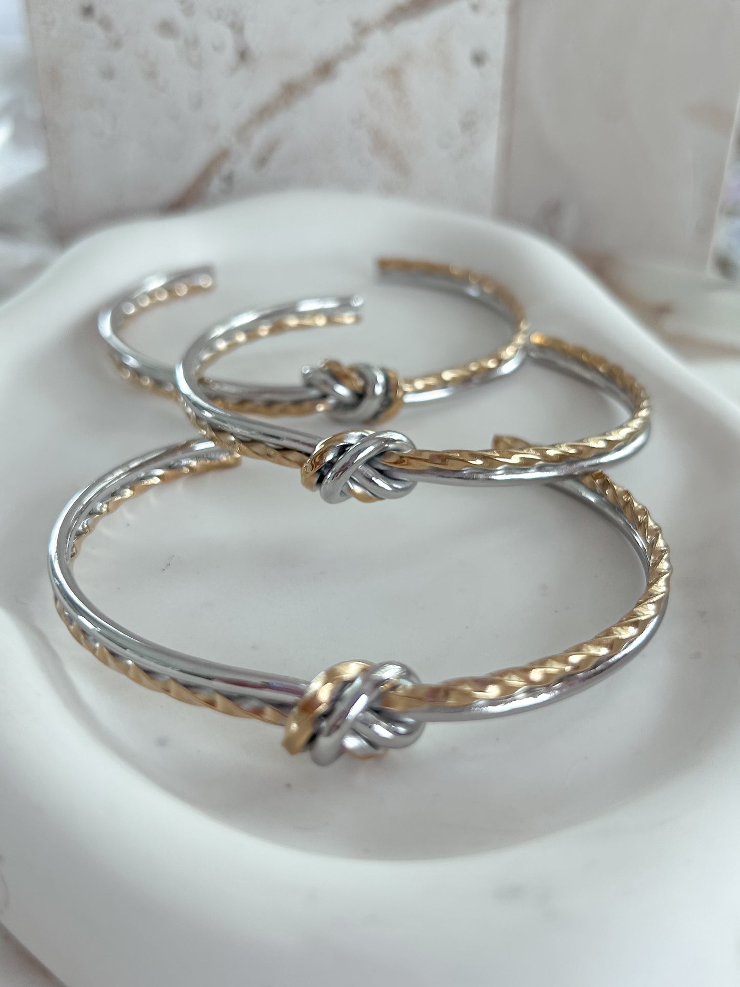 A cord of three strands two tone bangle