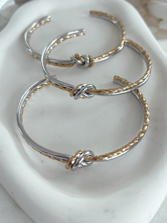 A cord of three strands two tone bangle